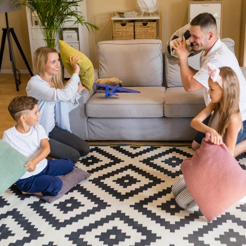 Family playing on a patterned area rug
